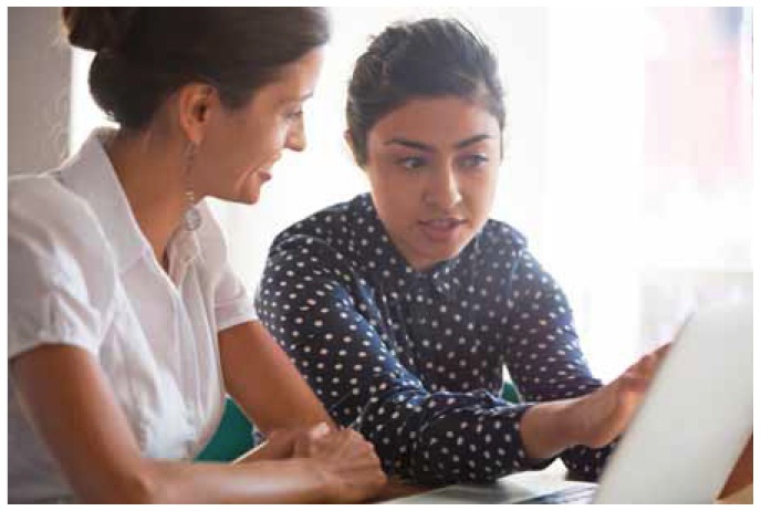 Description de l'image par IA : Deux femmes regardent un ordinateur portable ensemble.