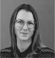 Description de l'image par IA : Femme aux cheveux longs et lunettes, souriant, en noir et blanc.